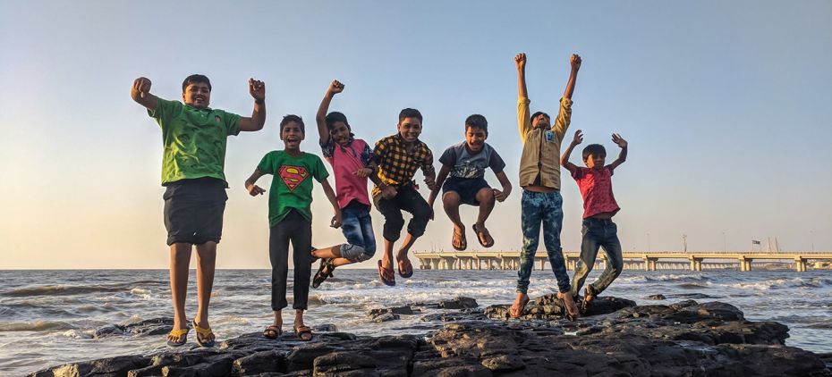 kids having fun jumping at the top of a mountain