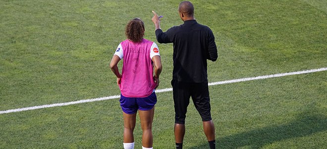 Coach teaching soccer player